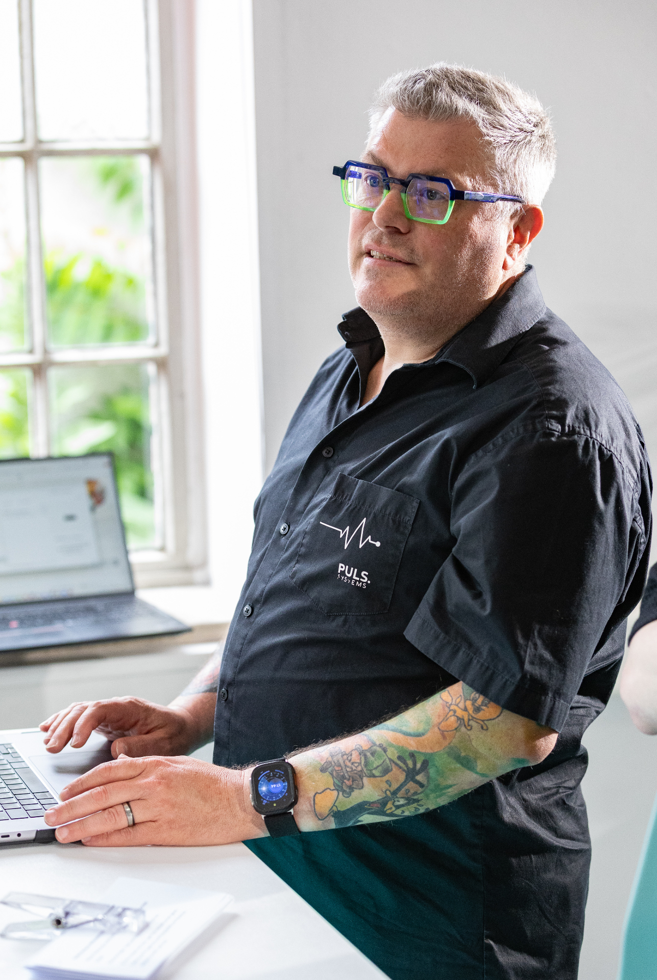 Oliver Puls bei der Arbeit am Laptop im hellen Büro